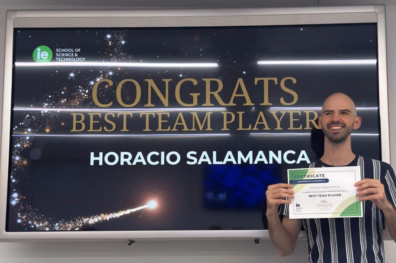 Horacio holding his Best Team Player certificate beside the IE award presentation