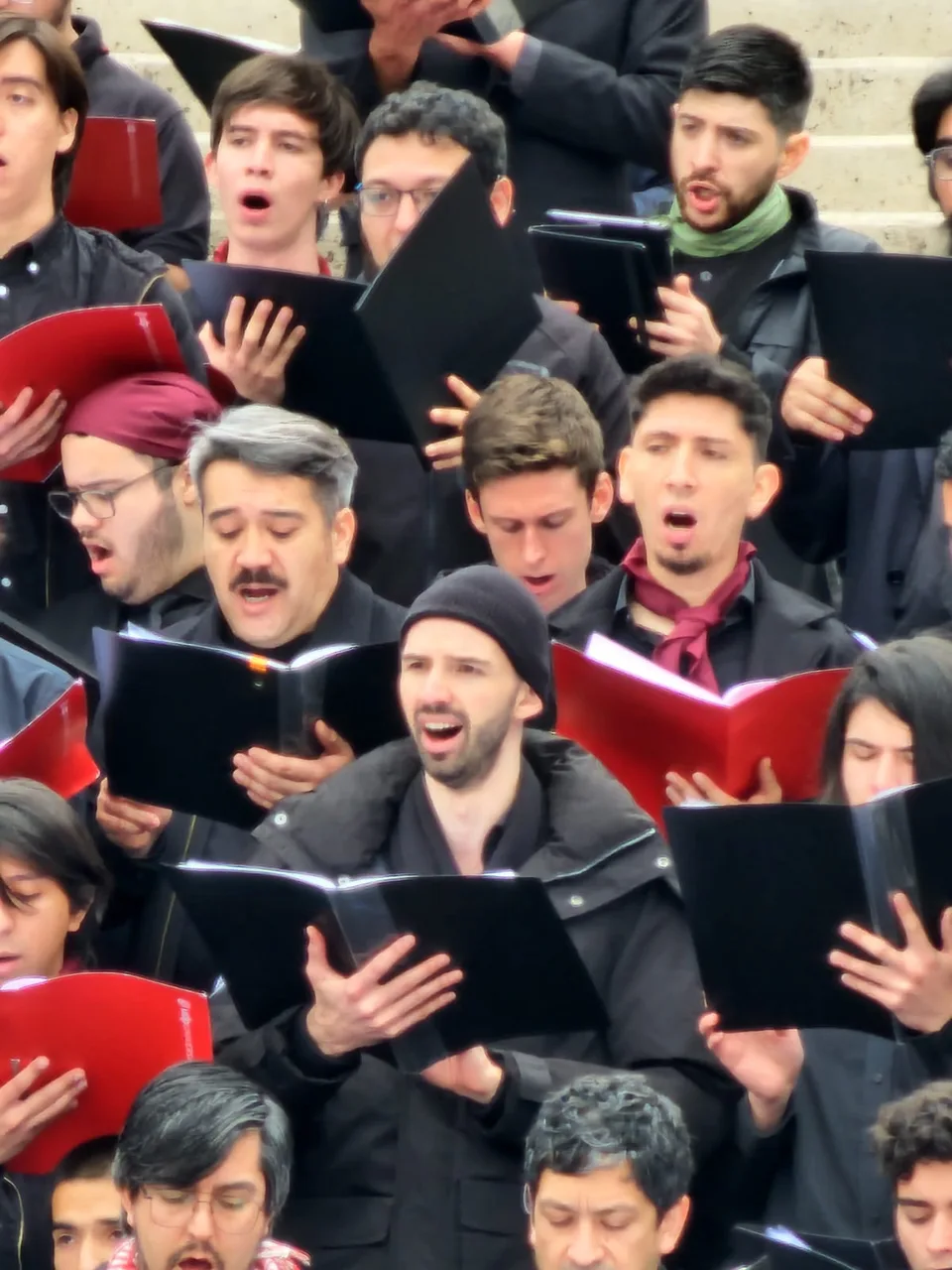 Choir members singing together with open music folders